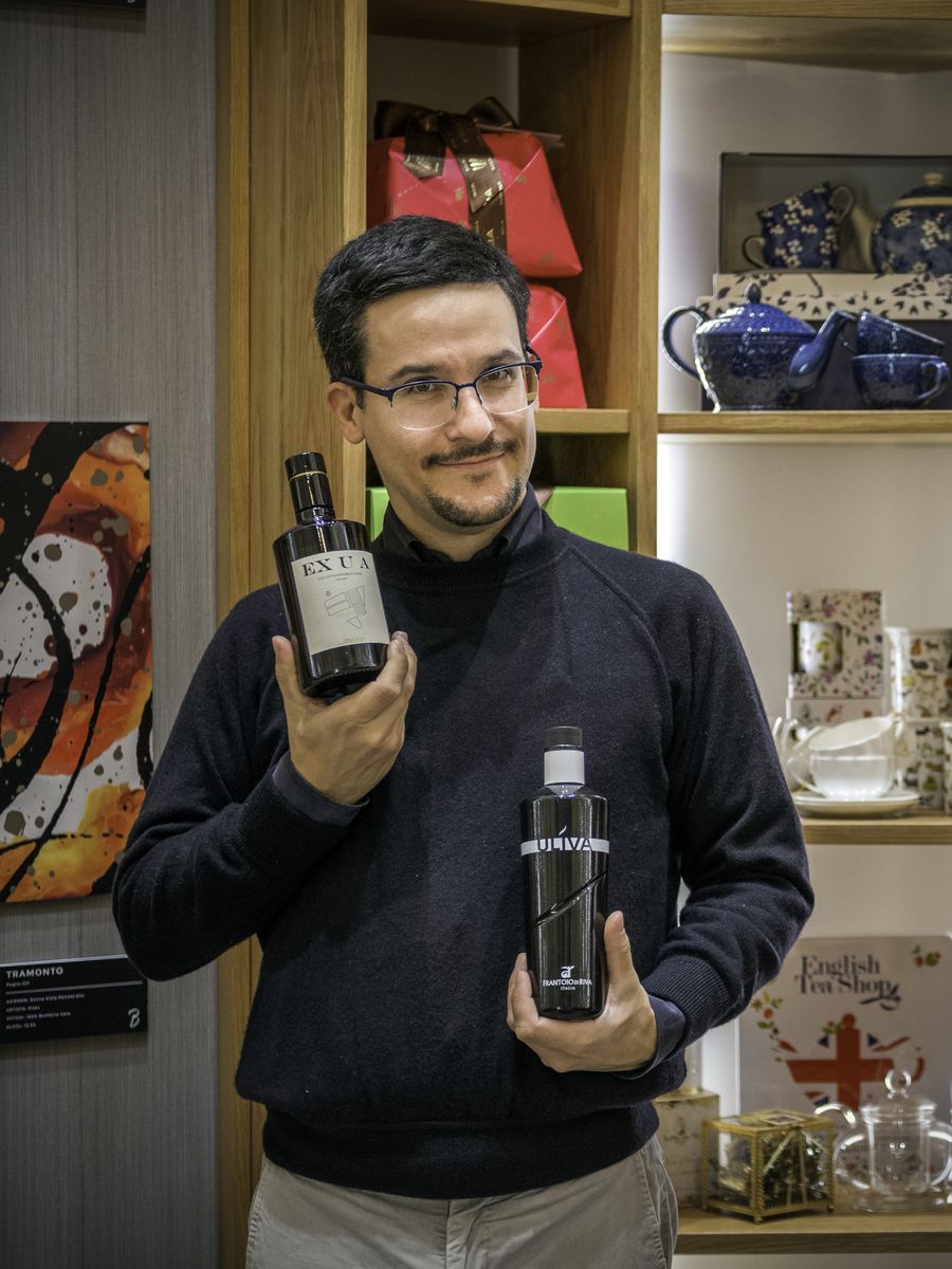 In bottega con due bottiglie di olio extravergine