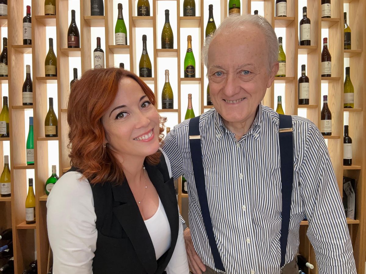 Accoglienza in bottega, davanti alla parete dei vini